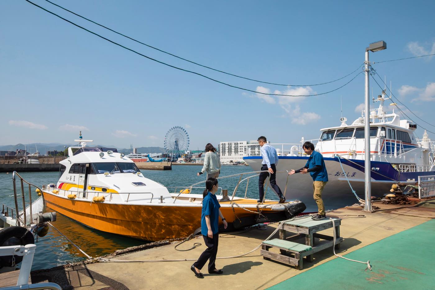 合同海洋散骨の乗船風景。スタッフがご遺族を船へご案内する様子