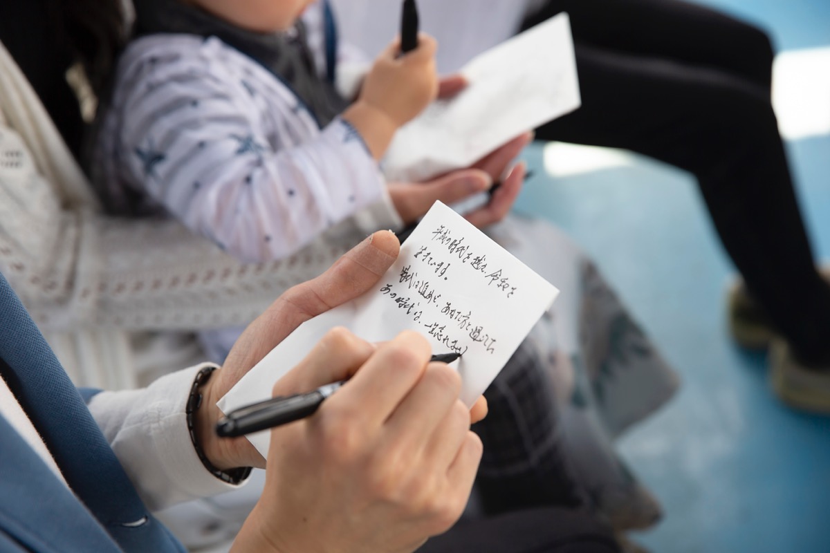 船上で故人さまへのメッセージカードを書くご家族