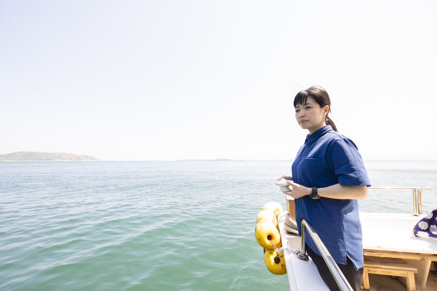 船上から海を見つめ、故人を偲ぶスタッフ